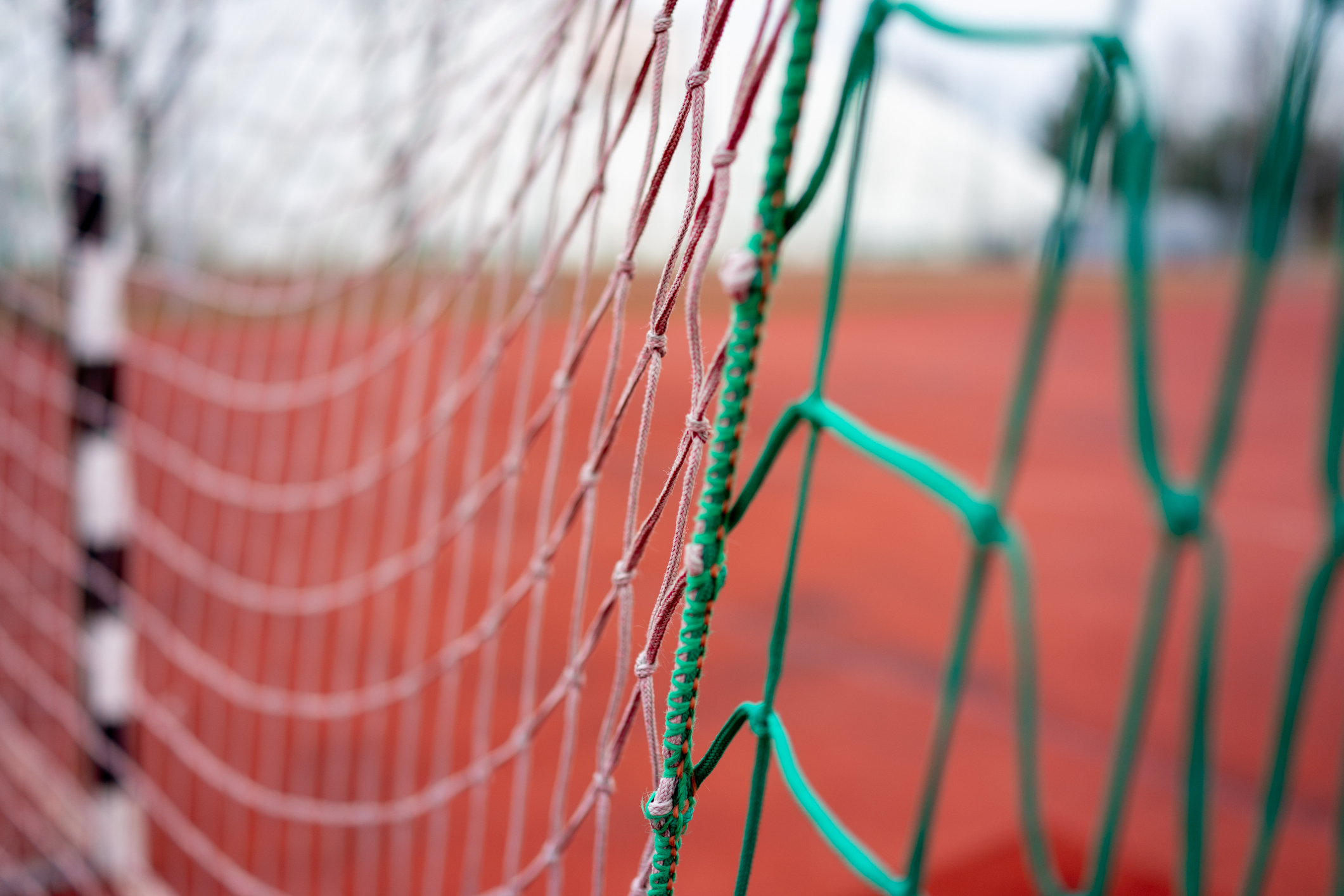Goal net details, Photograph capturing detailed goal net with stadium background and textured elements